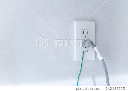 White wall outlet and power cable White wall outlet and power cable 142182215