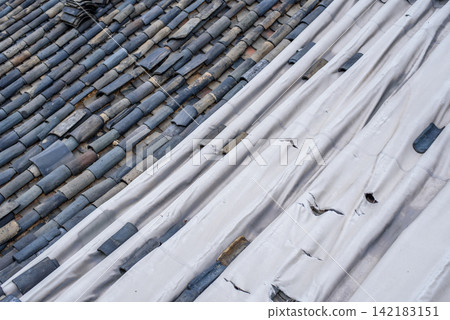 Terracotta tiles and corrugated white material on the roof Terracotta tiles and corrugated white material on the roof 142183151