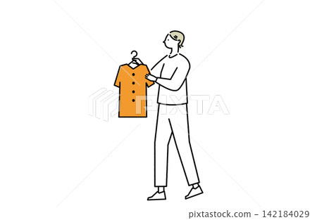 A woman picks up a piece of clothing. A woman picks up a piece of clothing. 142184029