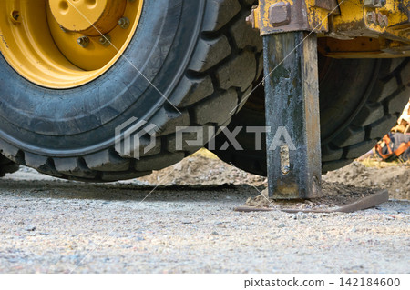 Work.Suspended rear wheel on hydraulic stops of bulldozer Work.Suspended rear wheel on hydraulic stops of bulldozer 142184600