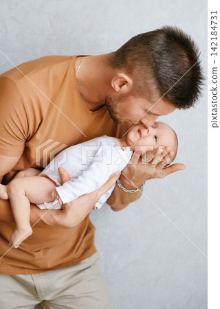 Loving Father Holding Newborn Baby Tenderly Loving Father Holding Newborn Baby Tenderly 142184731