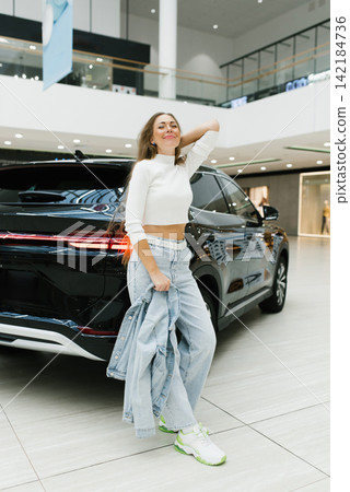 Customer Relaxing Near Luxury Vehicle in Shopping Center Customer Relaxing Near Luxury Vehicle in Shopping Center 142184736