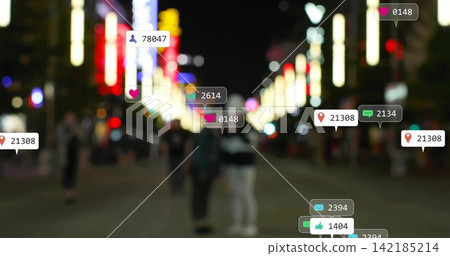 Standing two adults wearing coats on blurred night street, showing overlay UI icons over neon signs. Couple, silhouettes, urban, bokeh, storefronts, pedestrians, social 142185214
