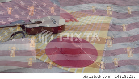 Resting red straw sun hat on yellow-striped towel at sandy beach, with ukulele and flag overlay. Headwear, guitar, picnic, seaside, coastal, outdoors, daylight Resting red straw sun hat on yellow-striped towel at sandy beach, with ukulele and flag overlay. Headwear, guitar, picnic, seaside, coastal, outdoors, daylight 142185233
