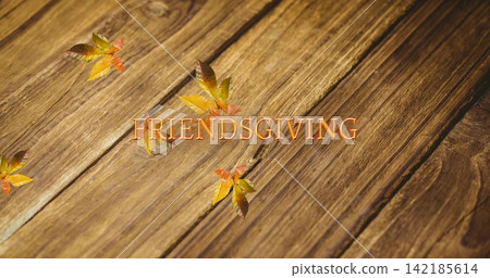Displaying warm orange FRIENDSGIVING lettering on rustic wood planks, with five autumn leaves. Typography, serif, font, leaf, fall, golden, amber Displaying warm orange FRIENDSGIVING lettering on rustic wood planks, with five autumn leaves. Typography, serif, font, leaf, fall, golden, amber 142185614