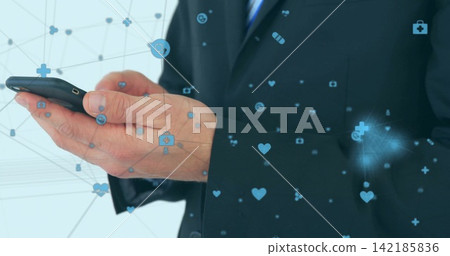 Tapping phone, businessman in suit and blue tie in office, holding smartphone with medical icons Tapping phone, businessman in suit and blue tie in office, holding smartphone with medical icons 142185836