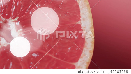 Showing halved grapefruit displaying translucent pulp in studio close-up, with bokeh spots Showing halved grapefruit displaying translucent pulp in studio close-up, with bokeh spots 142185988