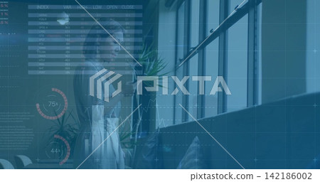 Standing midadult Asian woman in light blouse holding phone viewing data charts near windows plant Standing midadult Asian woman in light blouse holding phone viewing data charts near windows plant 142186002