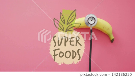 Displaying ripe banana with stethoscope on pink backdrop, pineapple graphic reading SUPER FOODS Displaying ripe banana with stethoscope on pink backdrop, pineapple graphic reading SUPER FOODS 142186230