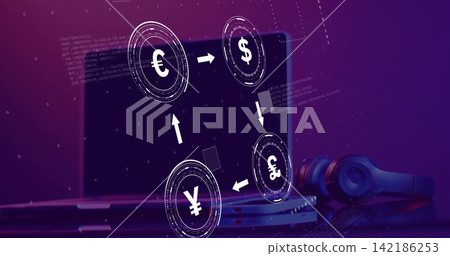 Displaying holographic currency exchange overlay hovering over laptop on desk, with headphones 142186253