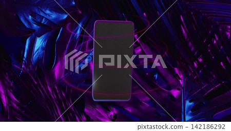 Floating smartphone hovering above glossy tropical leaves in studio, neon rings circling Floating smartphone hovering above glossy tropical leaves in studio, neon rings circling 142186292