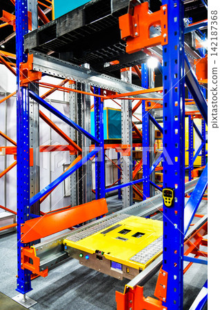 Automated pallet shuttle system running on steel racks in modern smart warehouse facility Automated pallet shuttle system running on steel racks in modern smart warehouse facility 142187368