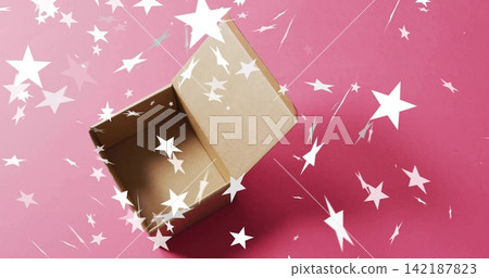 Sitting open brown corrugated cardboard box on pink paper, showing scattered white star confetti Sitting open brown corrugated cardboard box on pink paper, showing scattered white star confetti 142187823