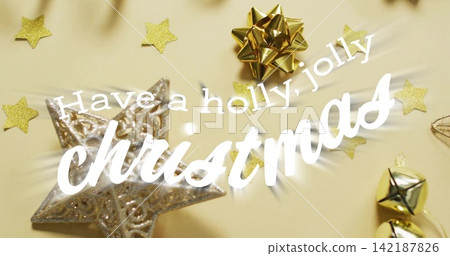 Displaying white cursive christmas greeting on beige background, with silver star, gold bow, bells 142187826