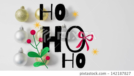 Featuring black HOHOHO lettering on white table with gold-silver-baubles, green-sprig, red-bow-on-O 142187827