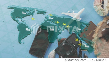 Displaying travel flatlay on blue table showing world map with model airplane, passport, DSLR, hat 142188346