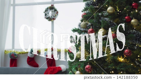 Decorating evergreen tree glowing with lights in home, Santa hat, CHRISTMAS text, copy space Decorating evergreen tree glowing with lights in home, Santa hat, CHRISTMAS text, copy space 142188350