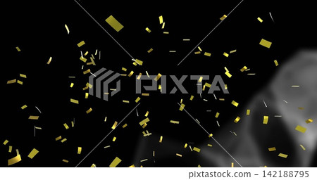 Falling metallic gold confetti pieces glinting on dark stage backdrop, with rising gray smoke plume Falling metallic gold confetti pieces glinting on dark stage backdrop, with rising gray smoke plume 142188795