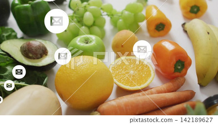 Showing bright fruits and veggies with halved avocado and orange on white tabletop, envelope icons 142189627