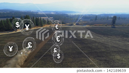 Showing drone filming tilled field on farm with tire tracks, truck kicking dust, currency icons 142189639