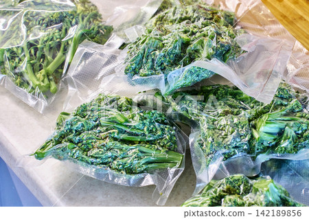 Vacuum packaging, freezing, broccoli portions rest on kitchen countertop, showing practical food storage after home meal preparation. Vacuum packaging, freezing, broccoli portions rest on kitchen countertop, showing practical food storage after home meal preparation. 142189856