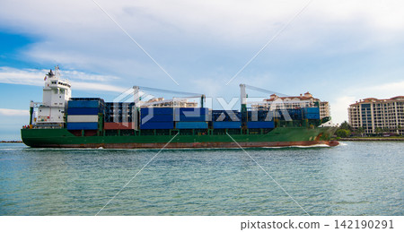 Container ship. Cargo ship with container. Freight container loaded on cargo vessel. View of cargo ship vessel navigating the sea leaving or entering harbor. Cargo business Container ship. Cargo ship with container. Freight container loaded on cargo vessel. View of cargo ship vessel navigating the sea leaving or entering harbor. Cargo business 142190291