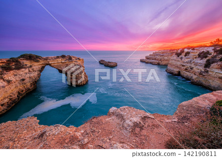 Dramatic Sunset at Arco de Albandeira Beside Rugged Sea Walls Dramatic Sunset at Arco de Albandeira Beside Rugged Sea Walls 142190811
