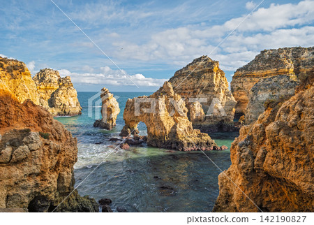 Ponte da Piedade sea stack and ocean cliff, Lagos Algarve Portugal with shore Ponte da Piedade sea stack and ocean cliff, Lagos Algarve Portugal with shore 142190827