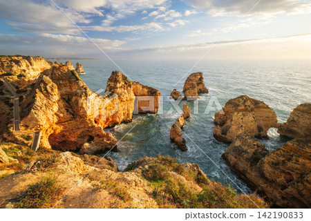 Ponte da Piedade sunrise cliffs and calm ocean in Lagos, Algarve Ponte da Piedade sunrise cliffs and calm ocean in Lagos, Algarve 142190833