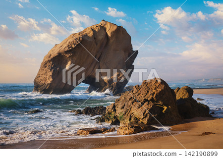 Exploring Penedo do Guincho rock arch at Praia da Santa Cruz during sunset Exploring Penedo do Guincho rock arch at Praia da Santa Cruz during sunset 142190899