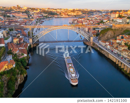 Drone View of tourist boat approaching Dom Luis I Bridge in Porto Drone View of tourist boat approaching Dom Luis I Bridge in Porto 142191100