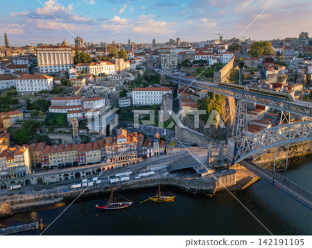 Sunrise drone view of tram on Dom Luis I Bridge beside Gaia waterfront Sunrise drone view of tram on Dom Luis I Bridge beside Gaia waterfront 142191105