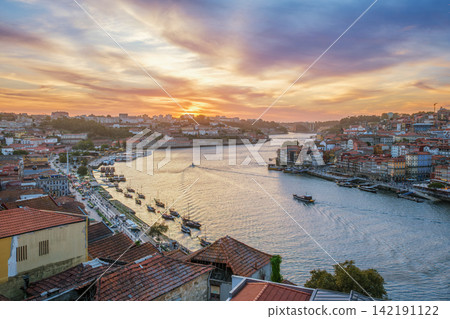Douro River sunset view in Porto with moving tourist boat and rabelo boats Douro River sunset view in Porto with moving tourist boat and rabelo boats 142191122