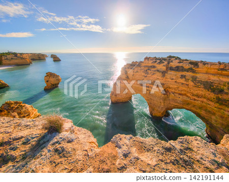 Praia da Marinha beach calm water ocean cliffs and sea stacks Algarve Portugal Praia da Marinha beach calm water ocean cliffs and sea stacks Algarve Portugal 142191144