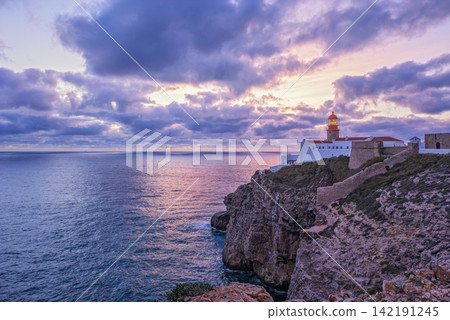 Cabo de Sao Vicente lighthouse at dusk below a cloudy sky in Sagres Cabo de Sao Vicente lighthouse at dusk below a cloudy sky in Sagres 142191245