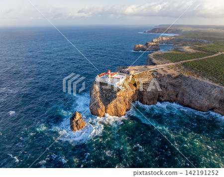 Aerial view of Cabo de Sao Vicente lighthouse at sunrise over the headland 142191252