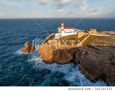 Cabo de Sao Vicente lighthouse at sunrise above an Atlantic rock stack Cabo de Sao Vicente lighthouse at sunrise above an Atlantic rock stack 142191353