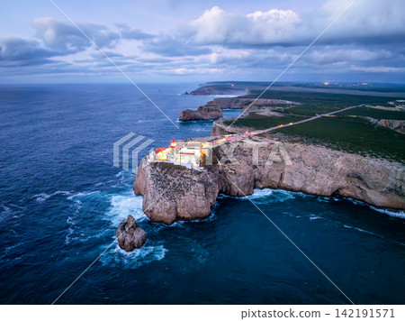 Aerial view of Cabo de Sao Vicente lighthouse in evening above shoreline surf Aerial view of Cabo de Sao Vicente lighthouse in evening above shoreline surf 142191571