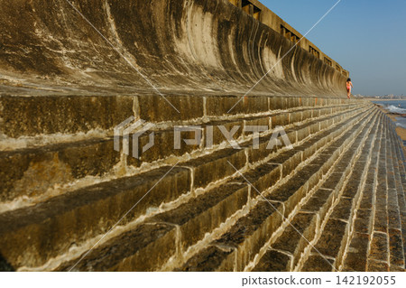 Rear view of a Girl walking Along Seaside Wall Rear view of a Girl walking Along Seaside Wall 142192055