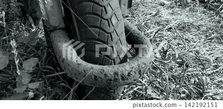 Black-and-white shot of a motorcycle tire with a rusty security lock. Black-and-white shot of a motorcycle tire with a rusty security lock. 142192151