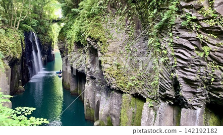 The fresh greenery of the columnar joints and the spray of the Manai Falls are reflected on the surface of the Gokase River (Takachiho Gorge/Takachiho Town, Nishiusuki District, Miyazaki Prefecture). 142192182