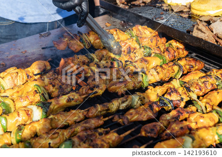Skewer meat cooking on barbecue, shashlik. Shish kebab on skewer. Chicken BBQ grill. Barbecue grill. Grilled chicken shish kebab. Delicious shish kebab with vegetables. Grilled BBQ pork. Street food Skewer meat cooking on barbecue, shashlik. Shish kebab on skewer. Chicken BBQ grill. Barbecue grill. Grilled chicken shish kebab. Delicious shish kebab with vegetables. Grilled BBQ pork. Street food 142193610