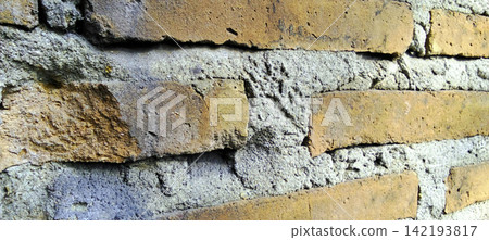 Weathered brick wall with rough cement joints. Weathered brick wall with rough cement joints. 142193817