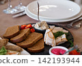 Gourmet Appetizer Platter with Rye Bread Slices Smoked Fish and Creamy Dip on Black Slate Table Setting 142193944