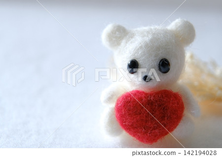 A wool felt polar bear hugging a red heart, copy space A wool felt polar bear hugging a red heart, copy space 142194028