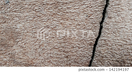 A pitted concrete surface with deep cracks. A pitted concrete surface with deep cracks. 142194197