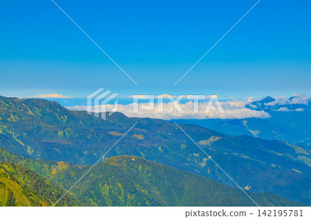 在一個晴朗的秋日早晨,從唐松山的登山小徑上,可以看到遠處的山脈,雲霧繚繞在色彩繽紛的山坡上。 在一個晴朗的秋日早晨,從唐松山的登山小徑上,可以看到遠處的山脈,雲霧繚繞在色彩繽紛的山坡上。 142195781
