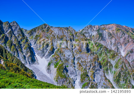 在一個晴朗的秋日早晨,從唐松山的登山道上可以看到白馬三峰山脈,天空湛藍如洗。 在一個晴朗的秋日早晨,從唐松山的登山道上可以看到白馬三峰山脈,天空湛藍如洗。 142195893
