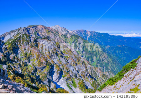 在一個晴朗的秋日早晨,從唐松山的登山道上可以看到白馬三峰山脈,天空湛藍如洗。 在一個晴朗的秋日早晨,從唐松山的登山道上可以看到白馬三峰山脈,天空湛藍如洗。 142195896
