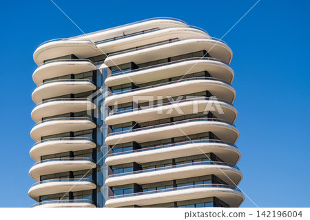 Architectural building in neighborhood. Building perspective. Condominium architecture. Architecture of residential building. Residential house. Modern condominium building. Modern condo amenities Architectural building in neighborhood. Building perspective. Condominium architecture. Architecture of residential building. Residential house. Modern condominium building. Modern condo amenities 142196004